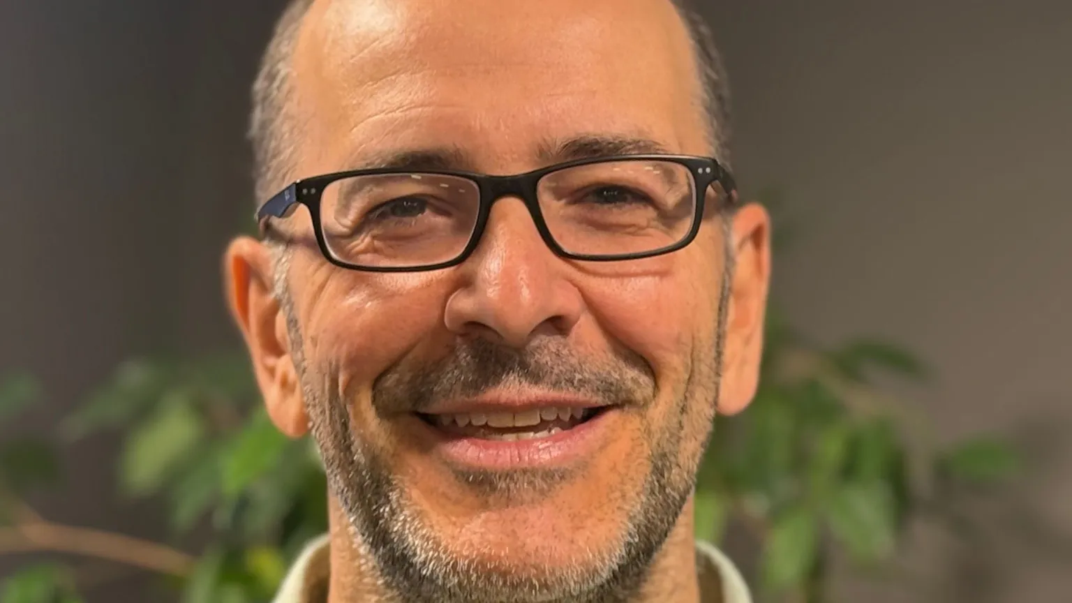 BBC James Howard wears glasses and a finely cut beard as he smiles straight toward the camera