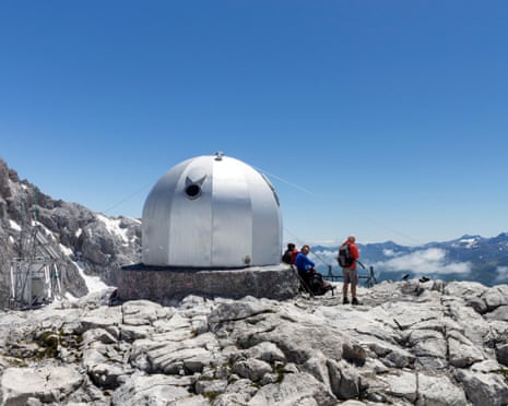 A silver dome-shaped building on a rocky mountaintop