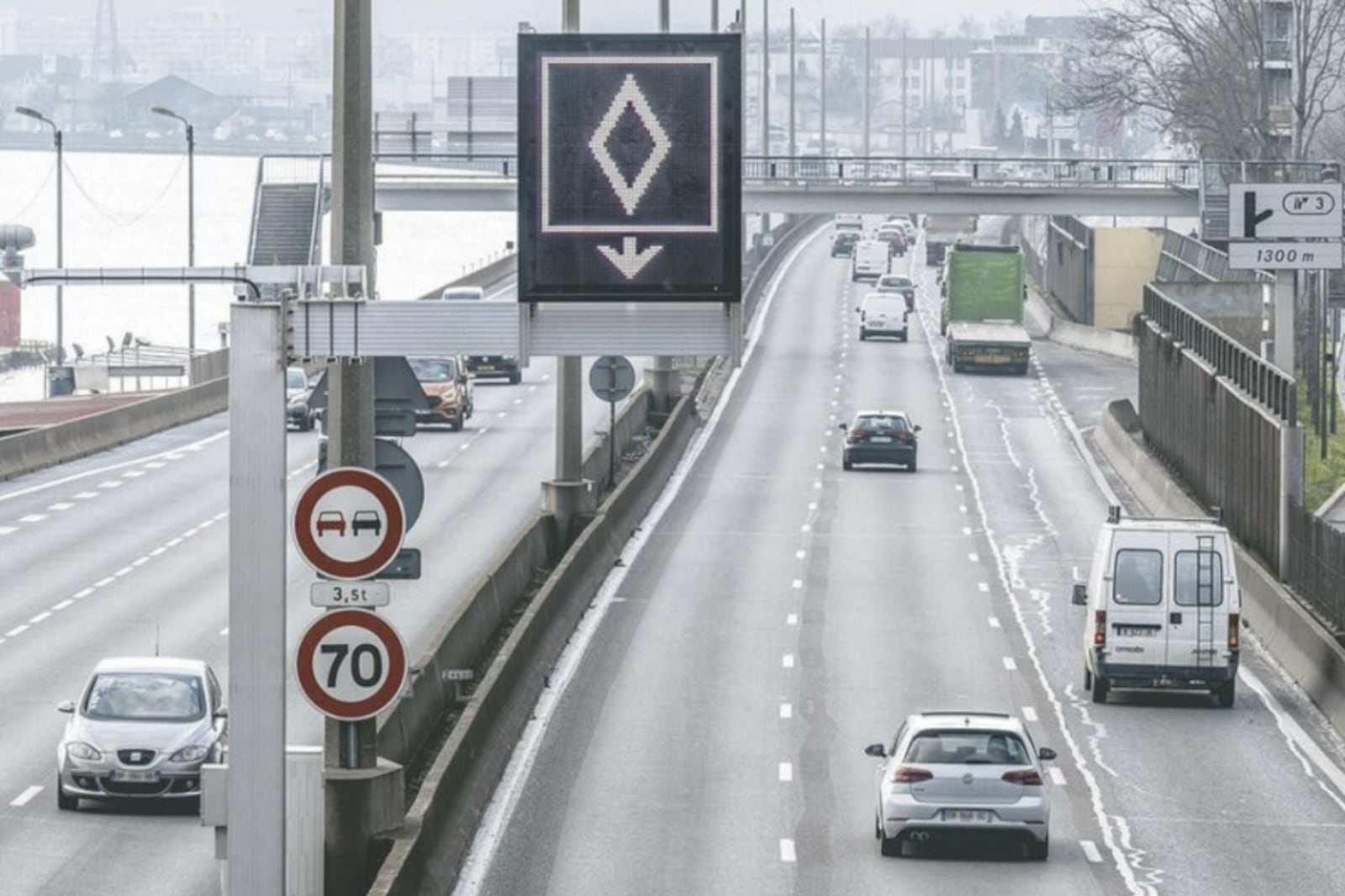 Carros circulam por rodovia da França em faixa com placa azul de trânsito com um losango branco